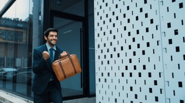 Şehir caddesinde yürürken neşeyle dans eden yetenekli bir iş adamı. Proje müdürü iyi haberler aldı, terfi aldı, başarılı bir iş buldu, aynı zamanda coşkuyu dile getirdi. Sevinçli..