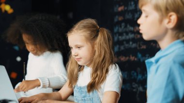 Akıllı kız, çeşitli arkadaşlarıyla dizüstü bilgisayar programlama kodları kullanıyor. Mikroçip ve ana pano dağılımı olan masa, BTMM sınıfında, karatahta, kodlama kombinasyonuyla yazılmış. Etkinlik.