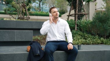 Kafkasyalı iş adamları Green City 'de otururken telefonla konuşuyor. Happy proje yöneticisi başarılı bir projeyi kutluyor ya da parkta dizüstü bilgisayarla çalışırken telefondan iyi haberler alıyor. Urbane.