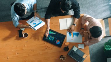 Yönetici, toplantı odasındaki meslektaşlarına mali grafiği açıklar. Farklı pazarlama ekibinin tabletle masada otururken fikir ve planlama stratejisini en üst düzeyde paylaşması. Cemaat.