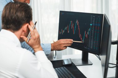 En yüksek borsayı işaret eden borsacı gerçek zamanlı izleme ekranı üzerinde dinamik değerli analiz araştırması yapan iş arkadaşını tanıtıyor. Finans şirketlerinin borsasında iş birliği yapıyor. Satılabilir.