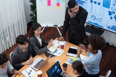 Modern toplantı odasındaki TV ekranında veri analizi paneliyle üst görünüm iş sunumu. İş adamlarının iş pazarlama stratejisini planlamak için beyin fırtınası yapması ya da birlikte çalışması. Uyum