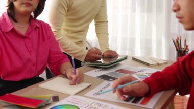 Grafik tasarımı için beyin fırtınası yapan ve renk seçimi yapan yavaş çekim tasarımcısı takımı ya da tasarımcı bürosunda krom danışmanlığı tavsiye isteyen bir müşteri. Değiştirilmiş