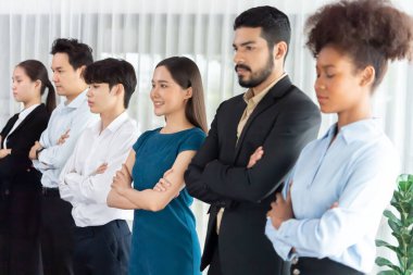 Profesyonel iş adamlarından oluşan çeşitli gruplar modern kurumsal ofiste çapraz kol hareketi ile sırada bekliyor. Mutlu ve gülümseyen, çok ırklı ofis çalışanı ekip birleşmesi ve birlikte başarılı. Uyum