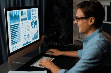Akıllı iş adamı iş paragrafı dinamik pazarlama analizi planını analiz ediyor. Kağıt kağıtları ve bilgisayar monitörü raporlarını gece evdeki belge verileriyle karşılaştırmak için hazırlıyor. Bireysel.