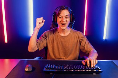 Kazanmak için çevrimiçi oyun oynayan akıllı flama makinesinin sunucu kanalı, neon ışıklı odada seçilen takım yarışması için izleyicilerle birlikte canlı yayında canlı yayında kulaklık takıyor. Bireysel.