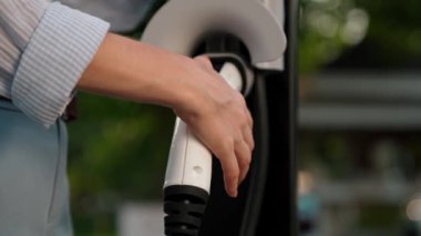 Otomobil seyahati sırasında elektrikli araba için şarj olan kadın Autumanl sezonunda doğal orman ya da milli parkta. Tatil ve tatil boyunca çevre dostu seyahat. Yükselt