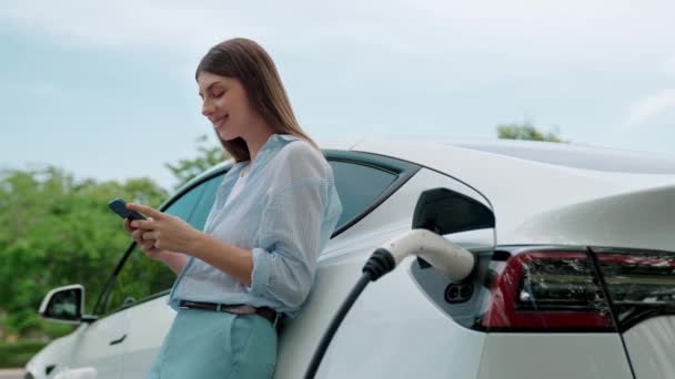 Kvinne Som Bruker Smarttelefon Online Bankapplikasjon Betale Elektrisk Bil Batteri – stockvideo