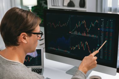 Akıllı yatırımcılar bilgisayar ekranlı ilginç borsa takasını işaret ediyorlar. Finansal teknoloji dinamik yatırım planı modern işyerindeki veri grafiğine odaklanıyor. Bireysel.