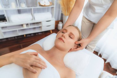 Kafkasyalı kadın stres önleyici kafa masajından ve lüks tatil beldesi ya da otel spa salonundaki modern ışık ortamında yüz güzelliği eğlencelerini şımartmaktan hoşlanıyor. Sessiz.