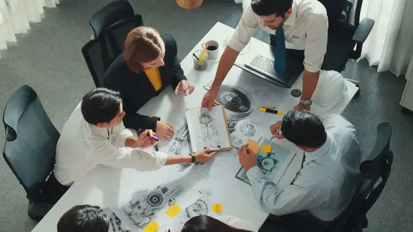 Group of diverse team planning strategy while sitting at table with project plan. Top aerial view of smart business people working together to brainstorm and design house construction. Alimentation.