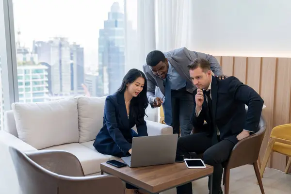 Diverse business team looking at laptop while discussing about business idea. Group of happy manager talking , thinking sharing business strategy while young businesswoman using laptop. Ornamented.
