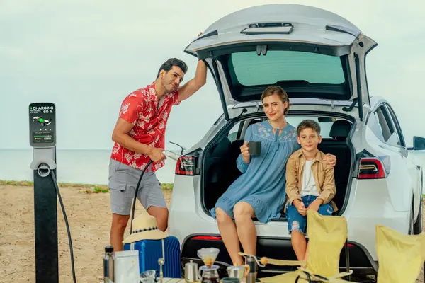 電気自動車でビーチで旅行する家族旅行 幸せな家族の再充電Ev車 屋外キャンプコーヒーを楽しむ きれいな環境のための海岸の旅行そして環境に優しい車 パーペチュアル — ストック写真
