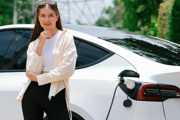 Jonge Vrouw Laad Haar Elektrische Auto Green City Park Parkeerplaats — Stockfoto