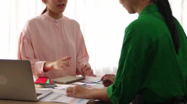 Yavaş çekim iki tasarımcı beyin fırtınası yapıyor ve grafik tasarımı için renk seçiyor ya da istemci renk bozukluklarını tasarımcı bürosundaki kromatik konsültasyonla karşılaştırıyor. Değiştirilmiş