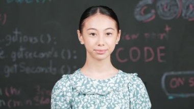 Mühendislik dersiyle tahtaya bakarken kameraya bakan beyaz tatlı bir kız. Kamera sistemi koduna gülümseyen yetenekli öğrenci STEM teknoloji sınıfında arkada yazılı. Öğretim