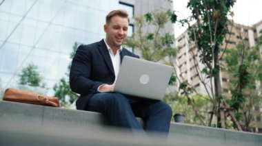 Dizüstü bilgisayarı üzerinde çalışan ve başarılı bir projeyi kutlayan ya da yeşil kentlerdeki satışları artıran bir yönetici. Profesyonel işadamı bankta otururken bilgisayar kullanarak analiz verilerine bakıyor. Urbane.