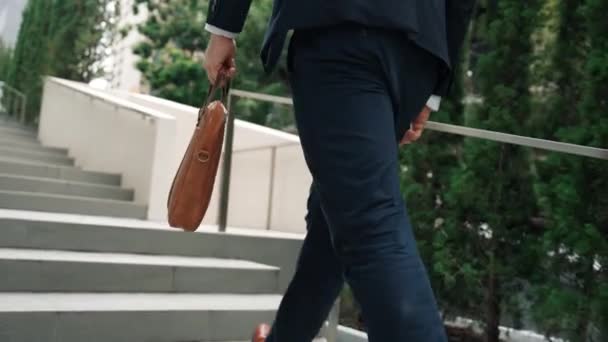 在绿城 身穿正装的白人经理拿着手提箱上楼去的背景图 在生态城市爬楼梯的时候 专业的商人要去工作 城市E — 图库视频影像
