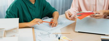 Akıllı iç dizayn ekibi proje için renk seçimini ev modelli renk örnekleri kullanarak ve renk örnekleri toplantı masasının etrafına dağılarak yapar. Yaratıcı tasarım konsepti. Değiştirilmiş.