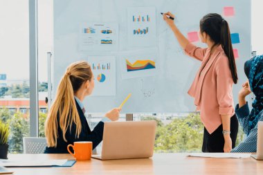 Çok kültürlü çalışma grubu. Farklı etnik kökenden iş kadınları, Kafkasyalı, Asyalı ve Araplardan oluşan bir ekip ofiste dizüstü bilgisayarla birlikte çalışıyor. Çok ırklı takım çalışması konsepti. uds