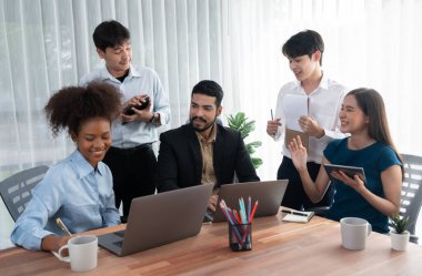 Mutlu iş adamları birlikte çalışır, şirket ofisinde tartışırlar. Profesyonel ve çeşitlilik takım çalışması iş planını bilgisayarda tartışır. Modern çok kültürlü ofis çalışanı. Uyum