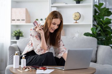 Genç mutlu kadın internetten alışveriş yaparak ürün satın alırken aynı zamanda internet üzerinden online ödeme sistemi ile çevrimiçi mağaza platformundan en yüksek siber güvenlik tarafından korunan ürünler sipariş ediyor.