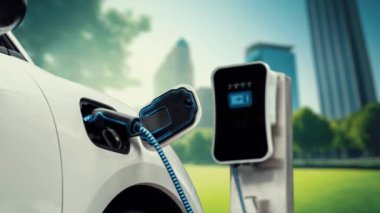 Yeşil Şehir Parkı 'ndaki ekolojik temiz enerji şarj istasyonundan gelen fütürist akıllı EV şarj aletinin şarj ettiği elektrikli araba. Alternatif enerji kullanan gelecekçi elektrikli araba. İnceleyin