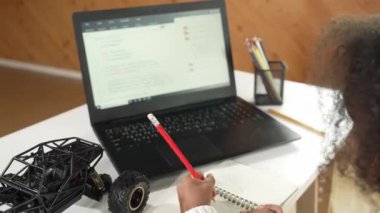 Akıllı Afrikalı kız sonuç yazarken dizüstü bilgisayar mühendisliği kodu. BTMM sınıfında bilgisayar programlama, kurma ve yazma komut kullanarak çalışan yaratıcı öğrenci. Etkinlik.