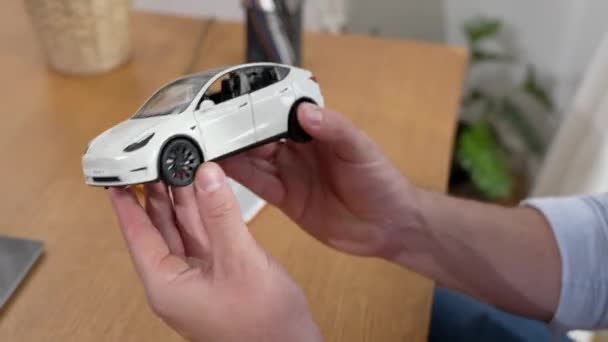 汽车设计工程师分析了汽车企业在总公司的汽车模型原型 汽车设计师手持比例汽车 仔细分析寻找任何缺陷或改进 太奇怪了 — 图库视频影像