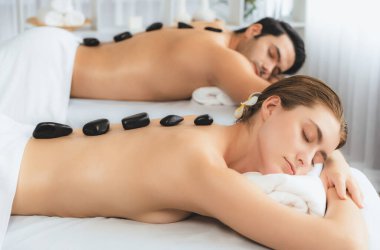 Lüks tatil köyündeki kaplıca salonunda sıcak taş masajı. Gündüz dinginliği ortam, mutlu çift müşterileri bazalt taşı masajının keyfini çıkarıyor. Rahatlatıcı bir sıcaklıkla vücudun üzerinde süzülüyorlar. Sessiz.