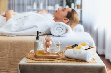 Aromaterapi masajı gündüz atmosferinde ya da spa salonunda bulanık bir kadına odak dekor ve spa aksesuarları kurarak tatil köyünde ya da otel arka planında keyifli aroma spa masajı yapan bir masaj. Sessiz.