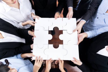 Üst düzey iş adamları yapboz parçalarını tutuyor ve bunları etkili çözüm çözümleri olarak birleştiriyor. Takım çalışması, ortak görüş ve çeşitli yetenekleri birleştiren ortak hedef. Çok titiz.