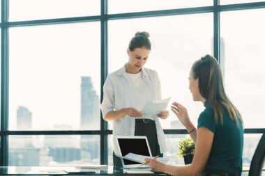 Profesyonel iş kadını, mali planı istatistiksel belge kullanarak tartışır. Modern ofiste beyin fırtınası yapan ve fikir paylaşan bir grup iş adamı. Birlikte çalışmak ve iş yapmak. İzleme.