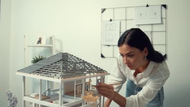 청사진이 벗겨진 사무실에서 연필을 사용하여 하우스 모델을 측정하는 아름다운 스마트 — 비디오
