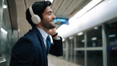 Tren istasyonunda geçmişi bulanık bir şekilde beklerken kulaklıkla müzik dinleyen zeki bir iş adamı. Yetenekli proje yöneticisi cep telefonu tutarken dinlenme sesi dinlemeyi sever. Sevinçli..