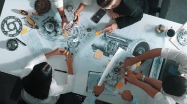 Mühendisin, toplantı masasındaki türbin motorunu ekipmanla gösteren üst düzey görüntüsü. Profesyonel proje yöneticisinin elektronik jeneratör sistemi hakkında konuştuğu ve tartıştığı hava görüntüsü. Hizalama.