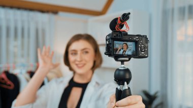 Kadın nüfuzlu kişi video görüntülerini canlı yayınlıyor. Kıyafetler sosyal medyada ya da blogda yer alıyor. Stüdyo ışıklandırmalı mutlu genç kız çevrimiçi pazarlama oturumu yayını için..