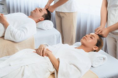 Kafkasyalı çift stres önleyici kafa masajının keyfini çıkarıyor ve lüks otellerde ya da otel spa salonlarında gündüz kaplıcalarında yüz güzelliği eğlencelerini şımartıyor. Sessiz.