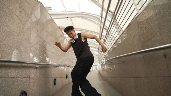 熟練したハンサムなヒップスターが狭い廊下でストリートダンスをするモーションショット プロのヒップホップダンサーは スタイリッシュな布を着用しながら廊下でBボーイステップを示しています アウトドアスポーツ 2024 スプライトリー — ストック写真
