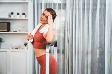 Spor ve atletik bir kadın, evdeki fiziğe ve sağlıklı spor yaşam tarzına uygun vücut egzersizi sırasında koşu bandında koşuyor. Gaiety evde egzersiz eğitimi.