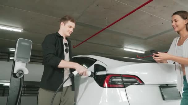 Genç Çift Uygulama Ekranında Elektrikli Araba Aküsü Şarj Durumu Menzil — Stok video