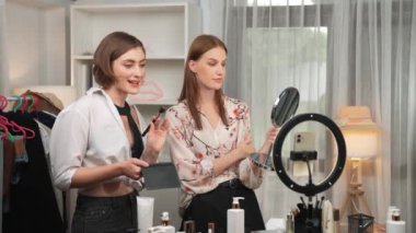 Etkilenen iki ortak canlı yayında video görüntülerini çekiyor makyaj malzemesi prim sosyal medya veya blog. Kozmetik stüdyosu ışıklandırmalı mutlu genç kız çevrimiçi pazarlama oturumu yayını için..