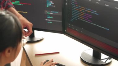 Yavaş çekimde geri uç veya yazılım geliştirici yöneticisi ekibini monitörde hata ayıklama ve karmaşık kod algoritmalarını çözmede yeni uygulama programı geliştirmede denetliyor. Filizlenen