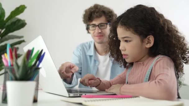 白人父亲帮助学生做工程代码的作业 而快乐的女生 爸爸带着可爱的孩子 一边教孩子们如何用笔记本电脑和耳机在餐桌边学习生成人工智能 教育学 — 图库视频影像