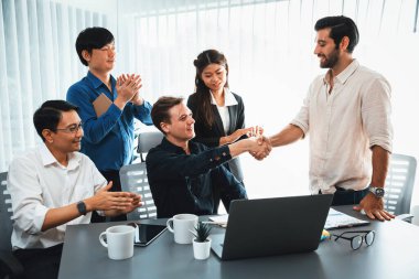 Çeşitli ofis çalışanları stratejik iş pazarlama toplantısı üzerine anlaşma yaptıktan sonra el sıkışıyor. Takım çalışması ve olumlu tutum verimli ve destekleyici bir iş yeri yaratır. Tedbirli