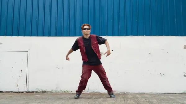 英俊的街舞选手在白色的后方操练霹雳舞 体育男子穿着嘻哈风格 同时移动脚步声到蓝色背景的街道上的音乐 2024年户外运动 奋斗者 — 图库照片