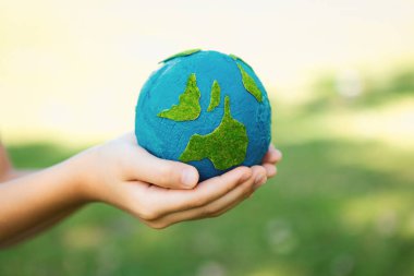 Dünya gezegenini ESG ilkesi ve çevre dostu enerjisiyle daha parlak bir gelecek için Dünya günü olarak el ele tutuşan genç çocuklar. Döngü