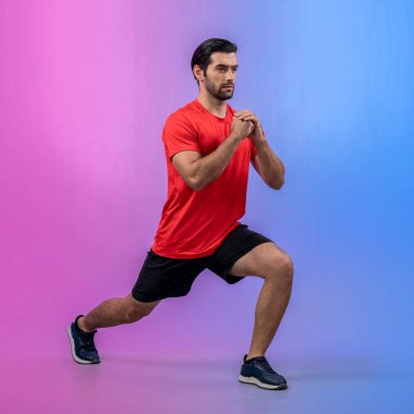 Vücut uzunluğunun tamamı atletik ve sportif genç bir adam tarafından izole edilmiş arka planda egzersiz pozisyonunda çekilmiştir. Sağlıklı aktif ve vücut bakımı yaşam tarzı.