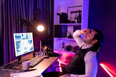 Akıllı iş adamının bitmemiş ürün satış kanalı raporuyla başı dertte. Gece geç saatlerde mor neon ışıklı odada çalışarak uzun süre analiz edilen pazar verileri kavramı. Tahmin et..