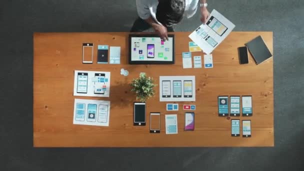 ミーティングルームでUx Uiデザインを探して選択するビジネスマンのトップビュー 創造的な職場で携帯電話インタフェースまたはソフトウェアアプリケーションを設計および計画する熟練した開発者 コンベンション — ストック動画